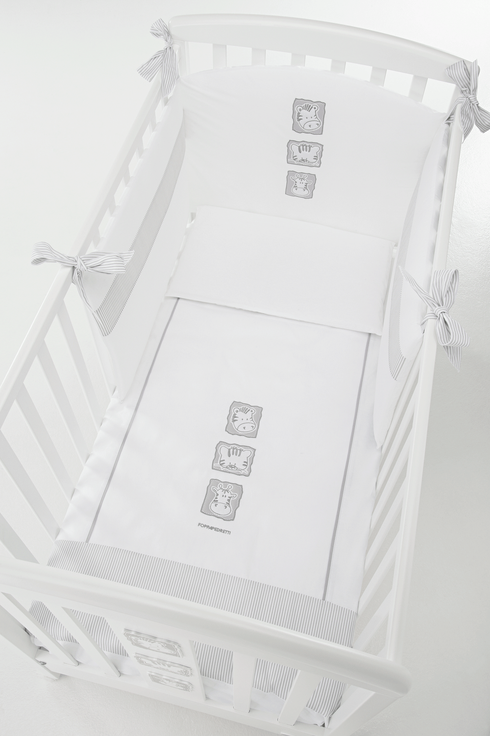 Babyzoo baby cot by Foppapedretti designed with one side adjustable into two heights and the baby cot can be opened at the side and folded up under the cot turned into a sofa.